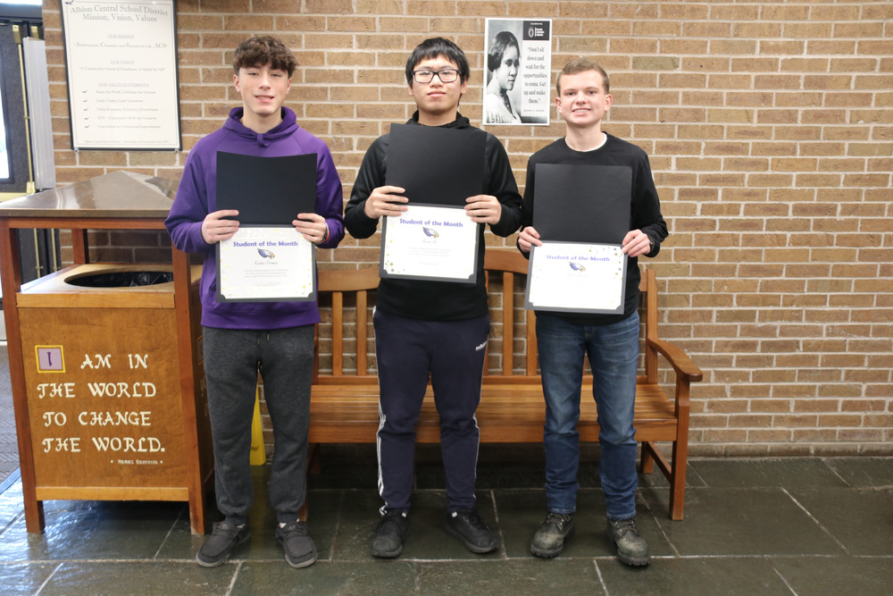 three students of the month with their certificates