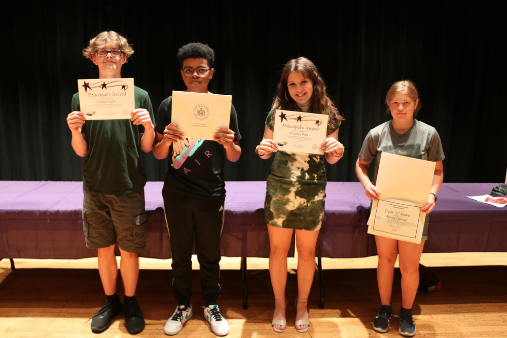 middle school award winners pose with their awards