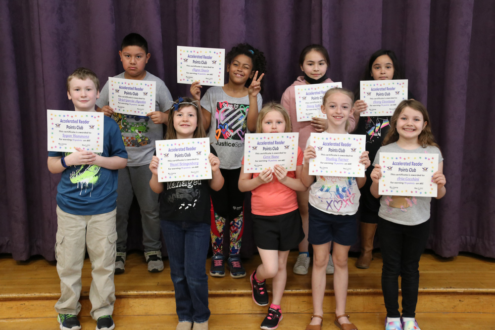 accelerated reader students stand with certificates