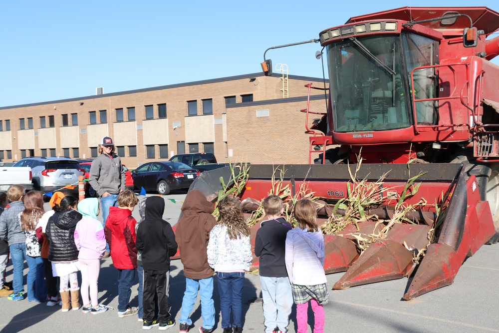 students learn about a combine from an FFA student