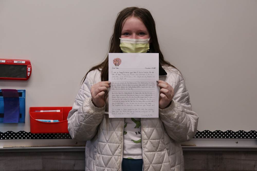 A student shows off her pen pal letter