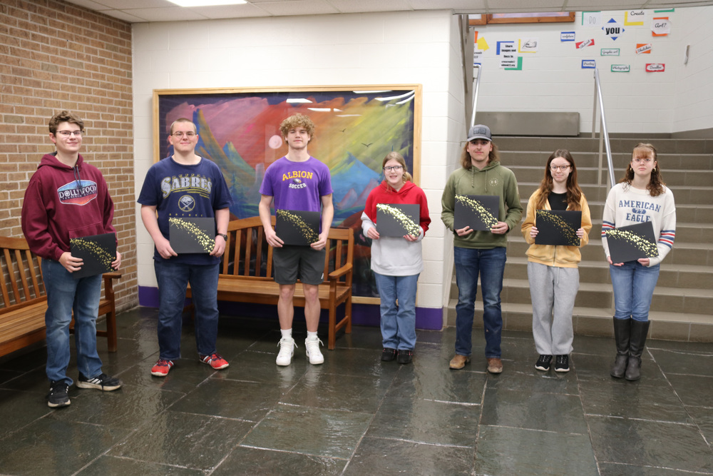 students of the month stand with their certificates