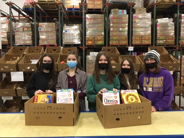 Interact students pose with boxes of food