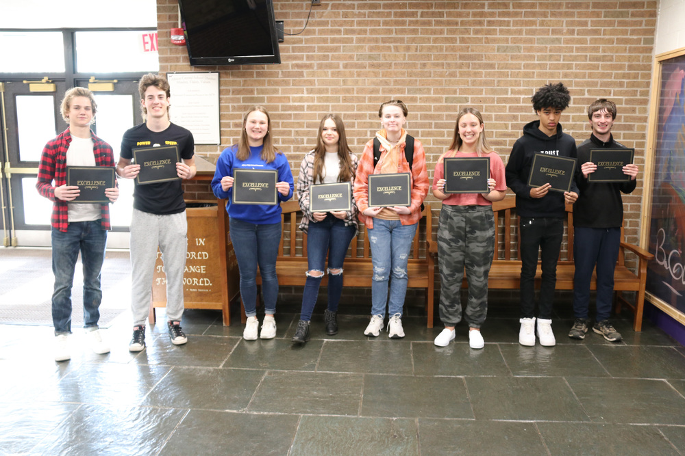 students of the month stand with certificates