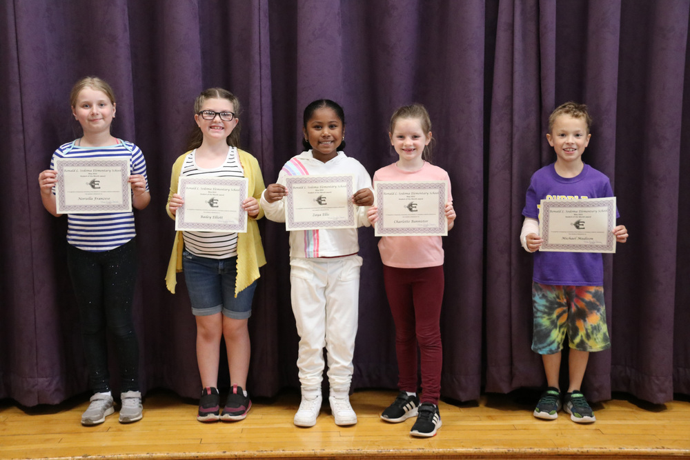 students of the month pose with certificates