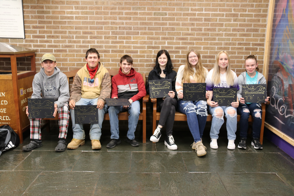 students of the month sit on bench