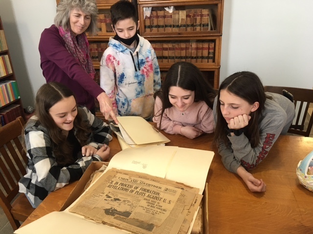 students examine documents with historian