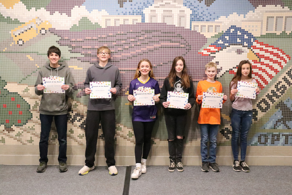 students of the month stand with their certificates