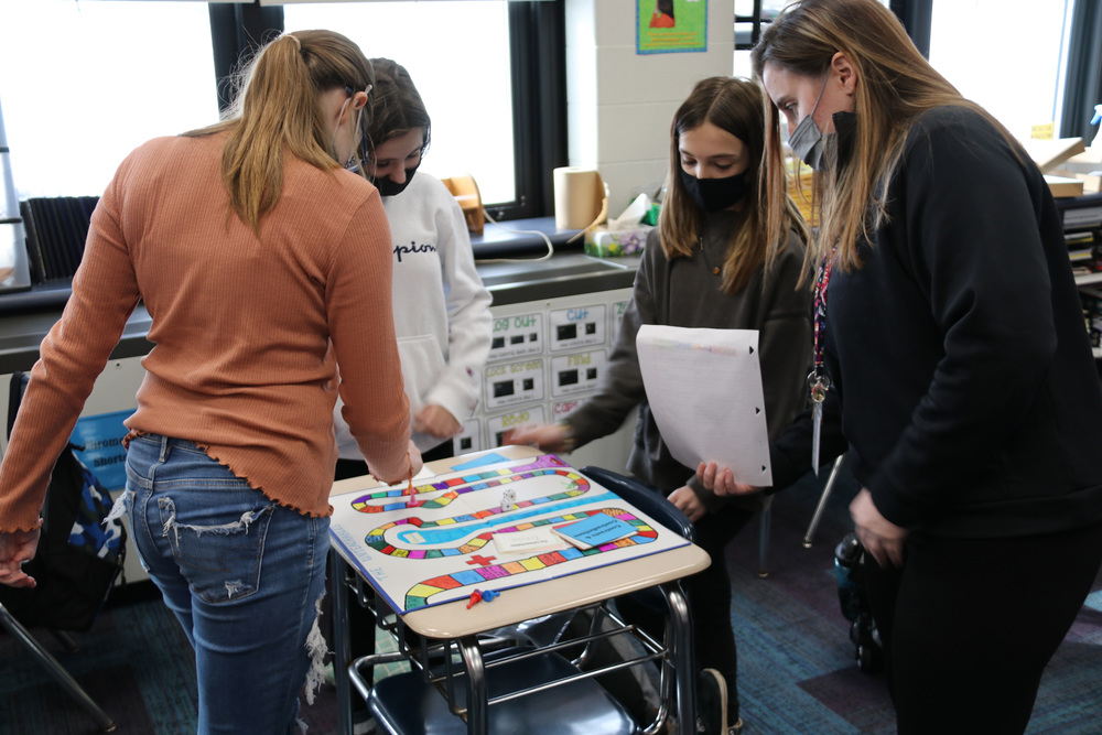 students play their created board game with Ms. LaSpina