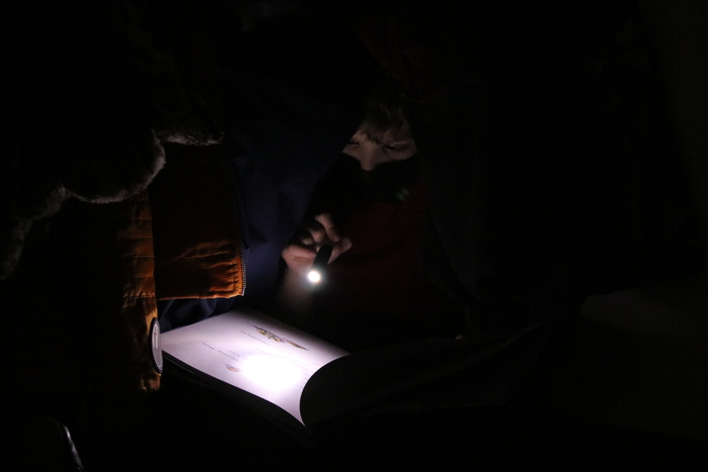 students reading by flashlight