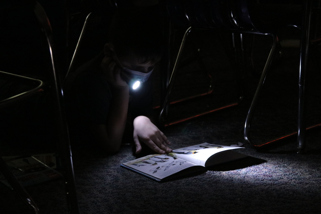 students reading by flashlight