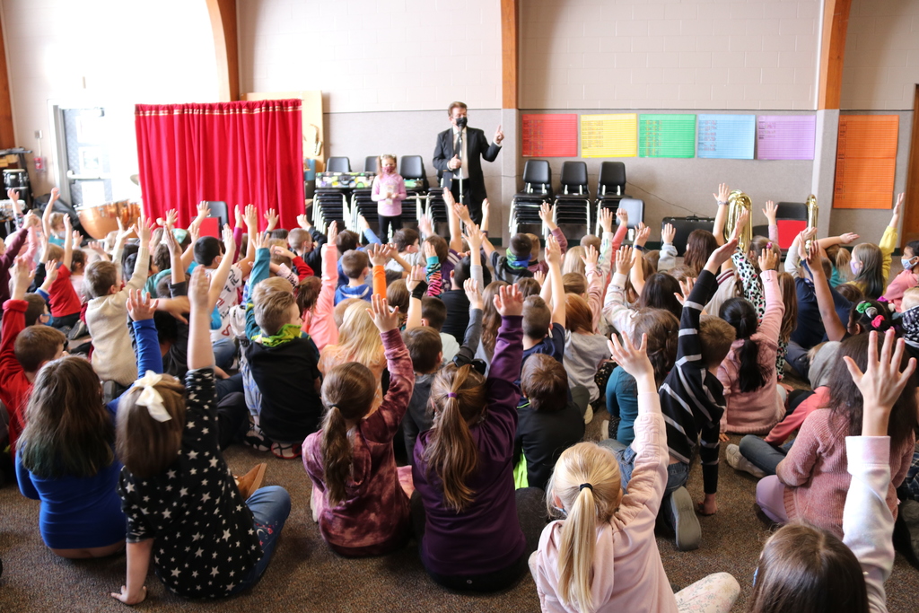 students raise their hands at the magic show