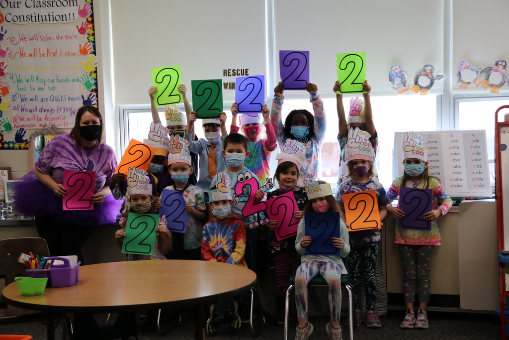 Students pose holding "2" signs