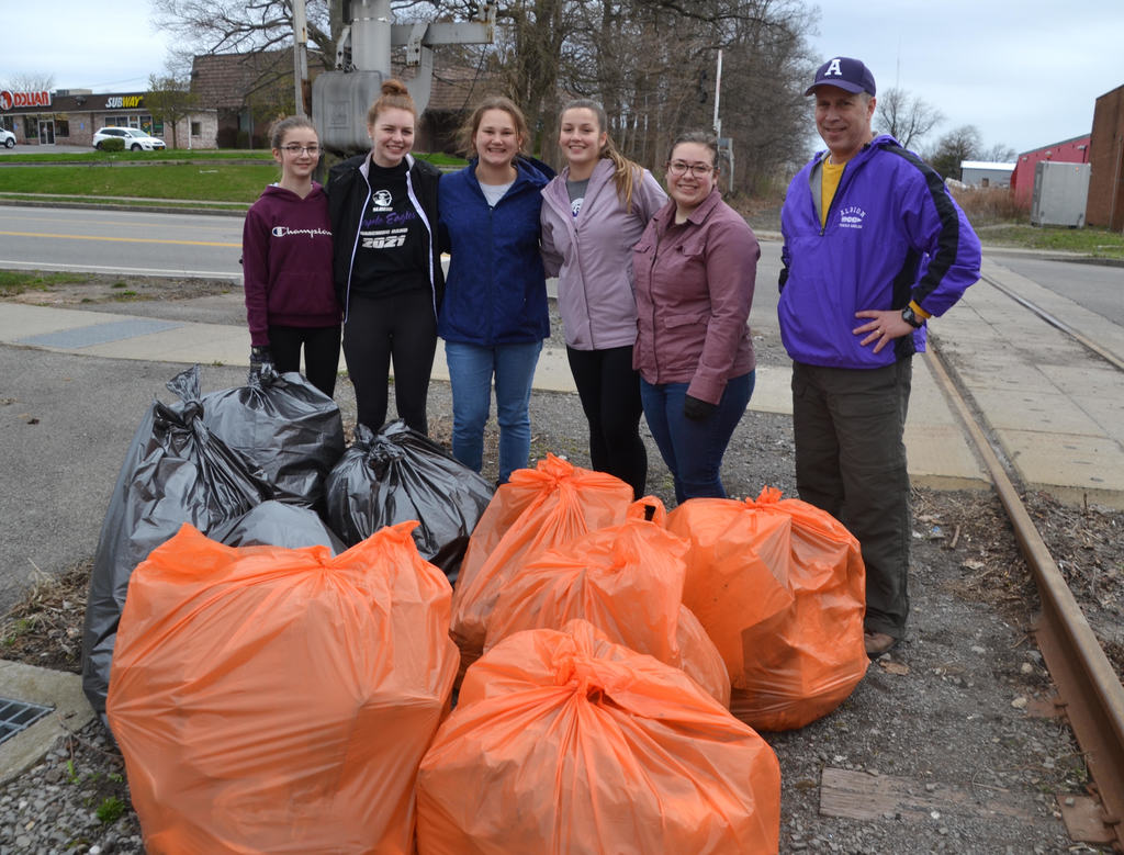 group shows off bags of trash collected