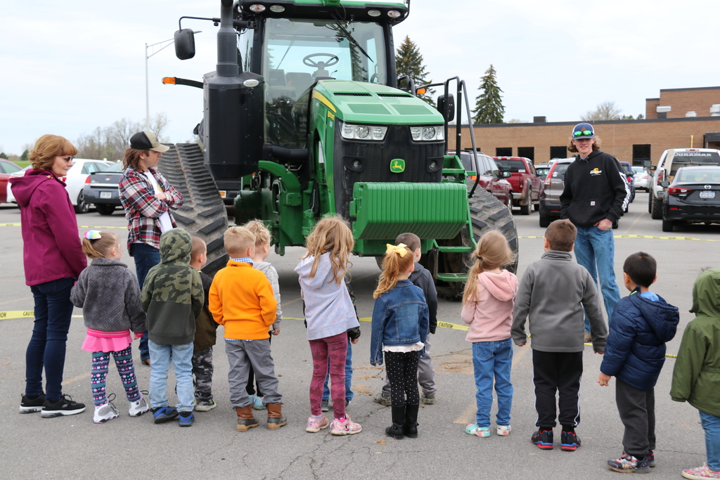 students gather around a tractor