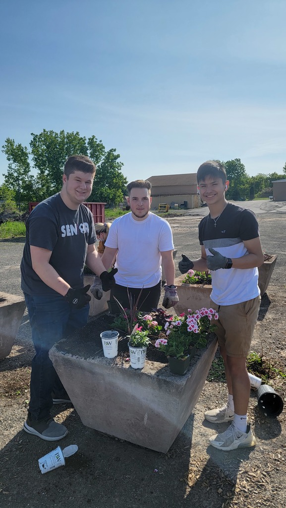 students plant flowers in planters