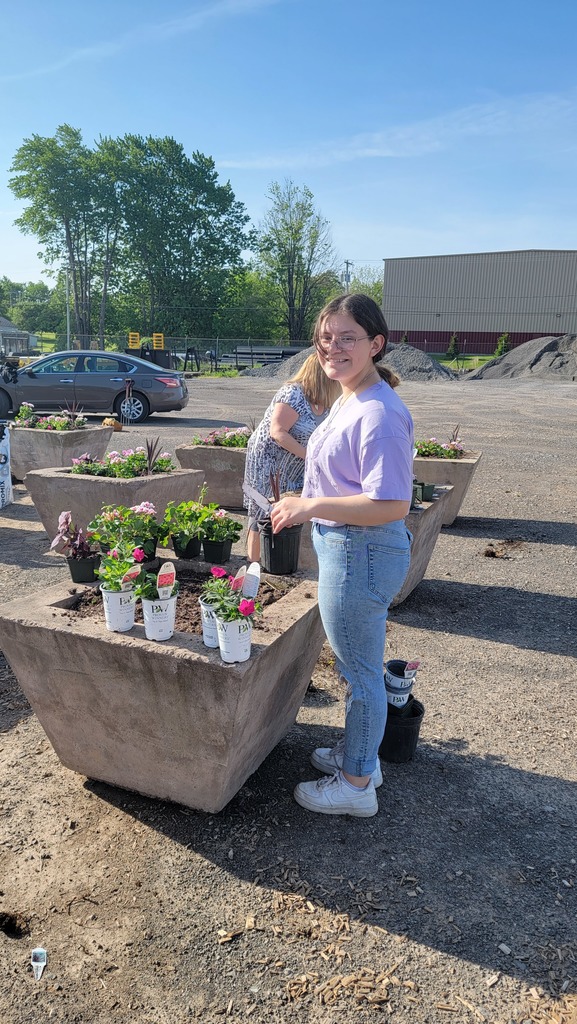 student plants flowers in planters