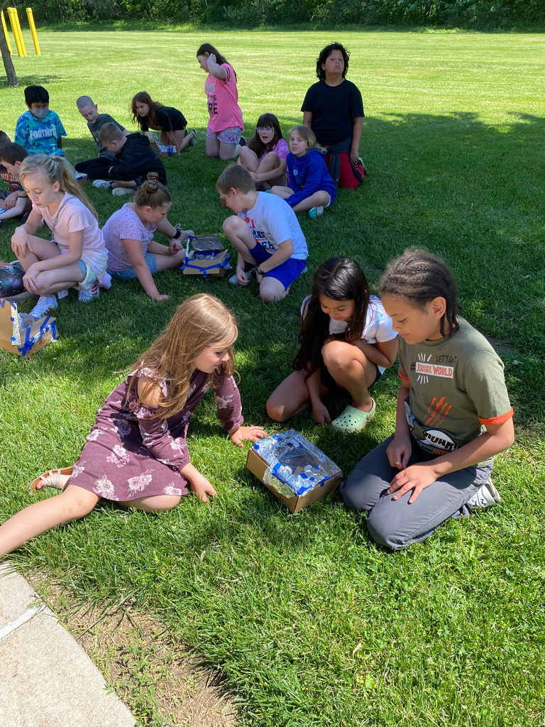 students watch their solar oven cook s'mores