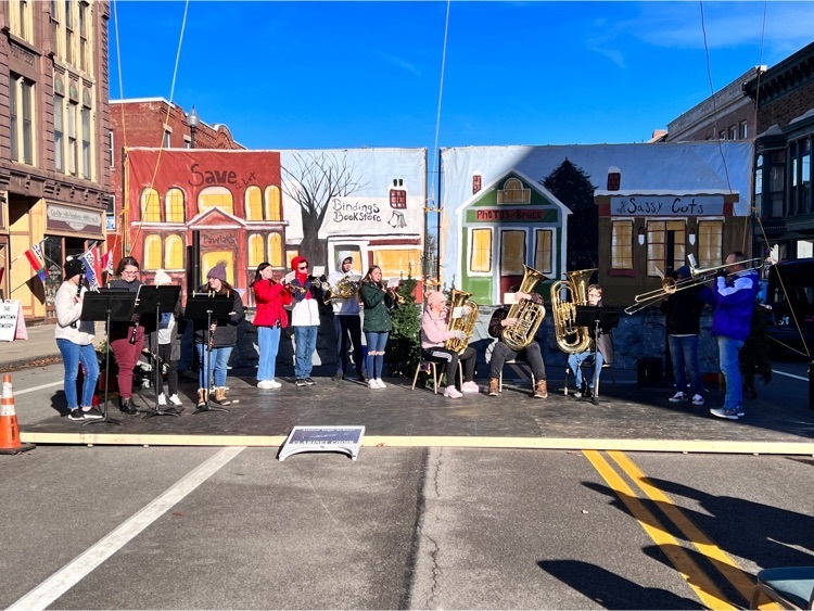 hs band members play Christmas songs in downtown