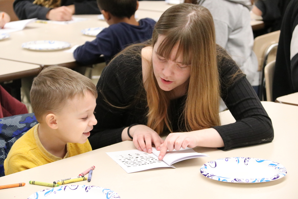 a high school student works with a preK student