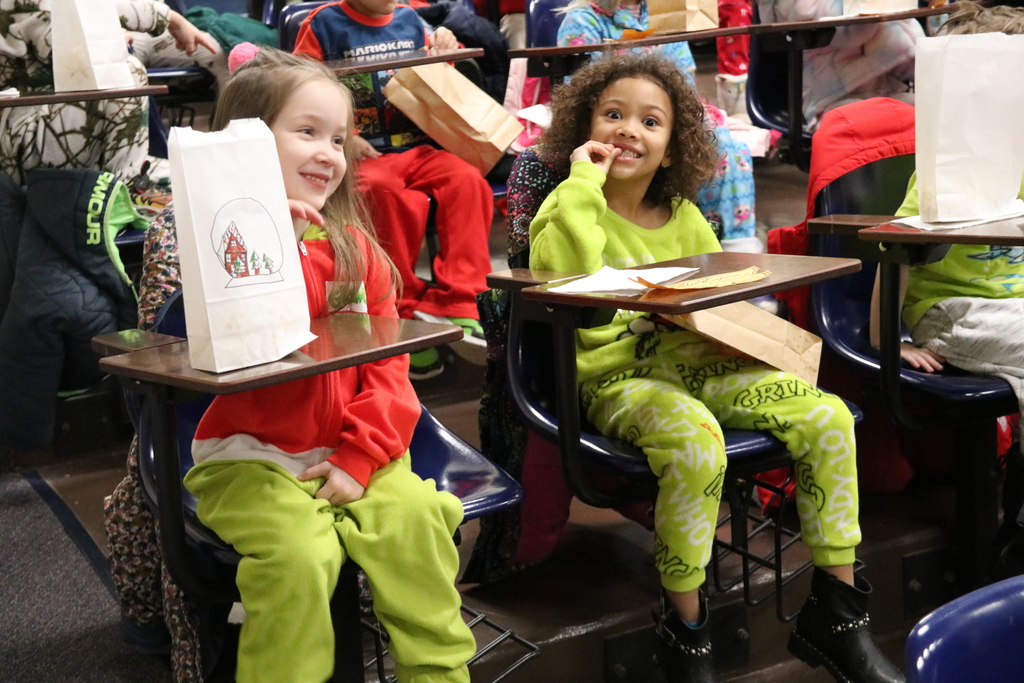 students dressed in Grinch pajamas eat popcorn
