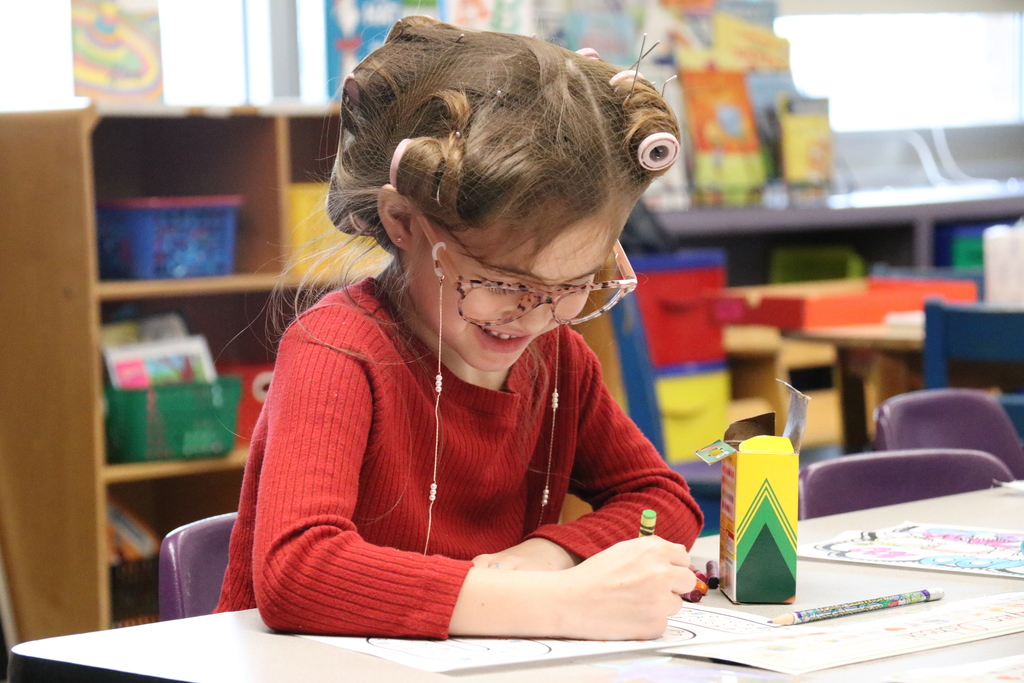 a student works with curlers in her hair