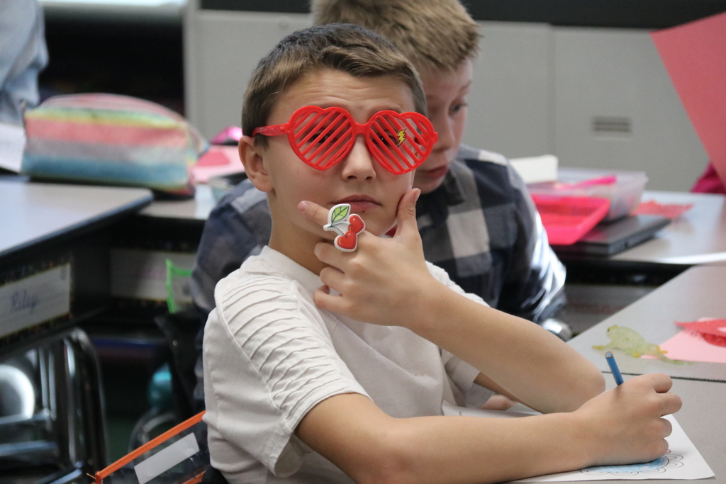 a student poses in heart-shaped glasses