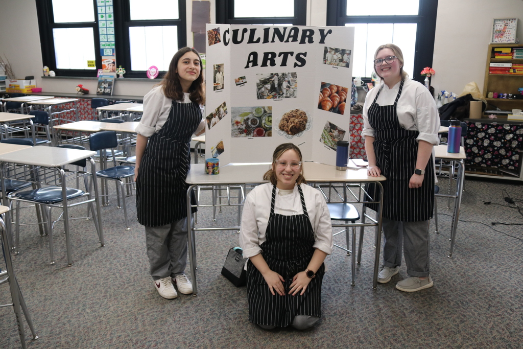 culinary arts students pose by their display